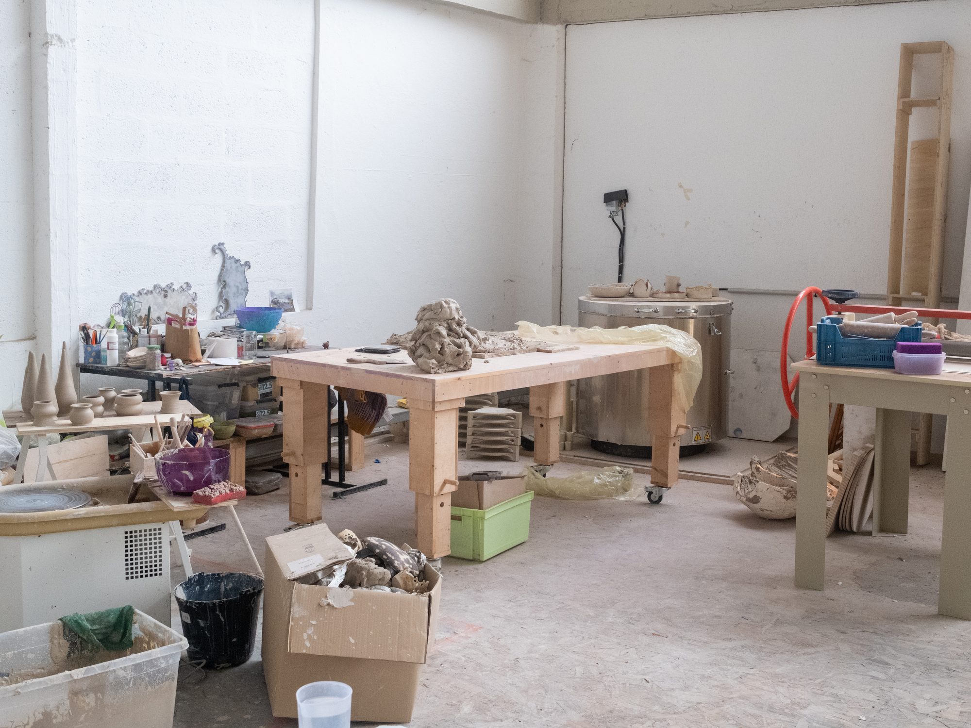 Atelier de céramique avec tables de travail et pièces en cours