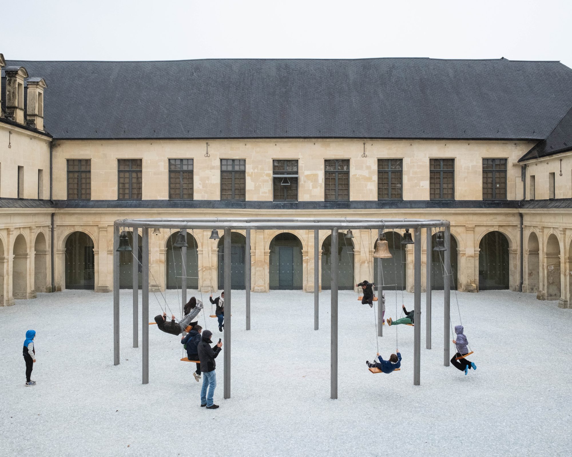 Structure circulaire avec balançoires occupées par des visiteurs