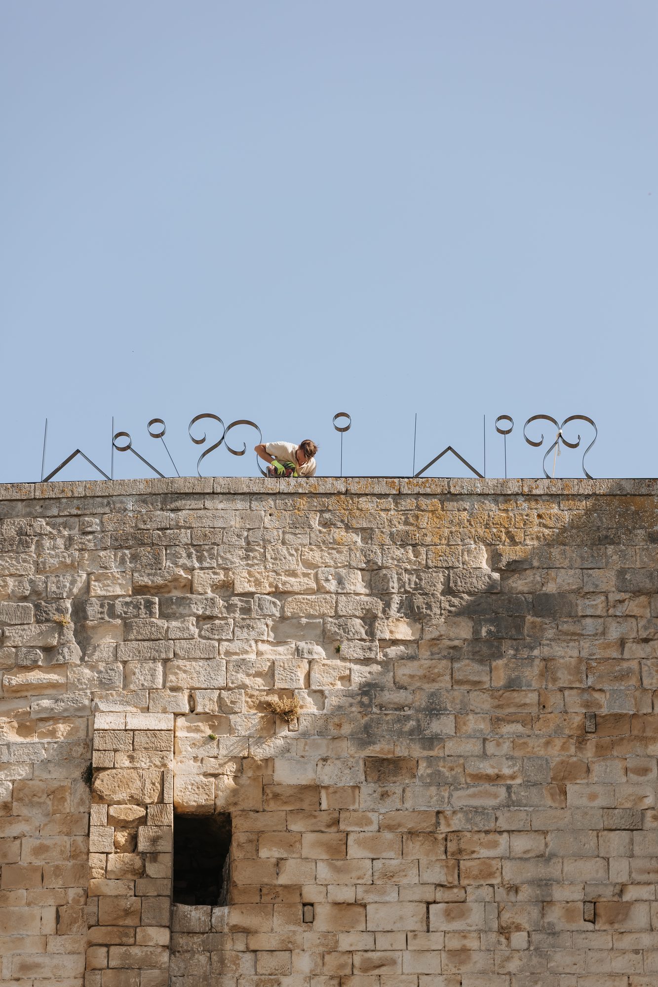 Lettres d’acier en haut d’un mur de pierre
