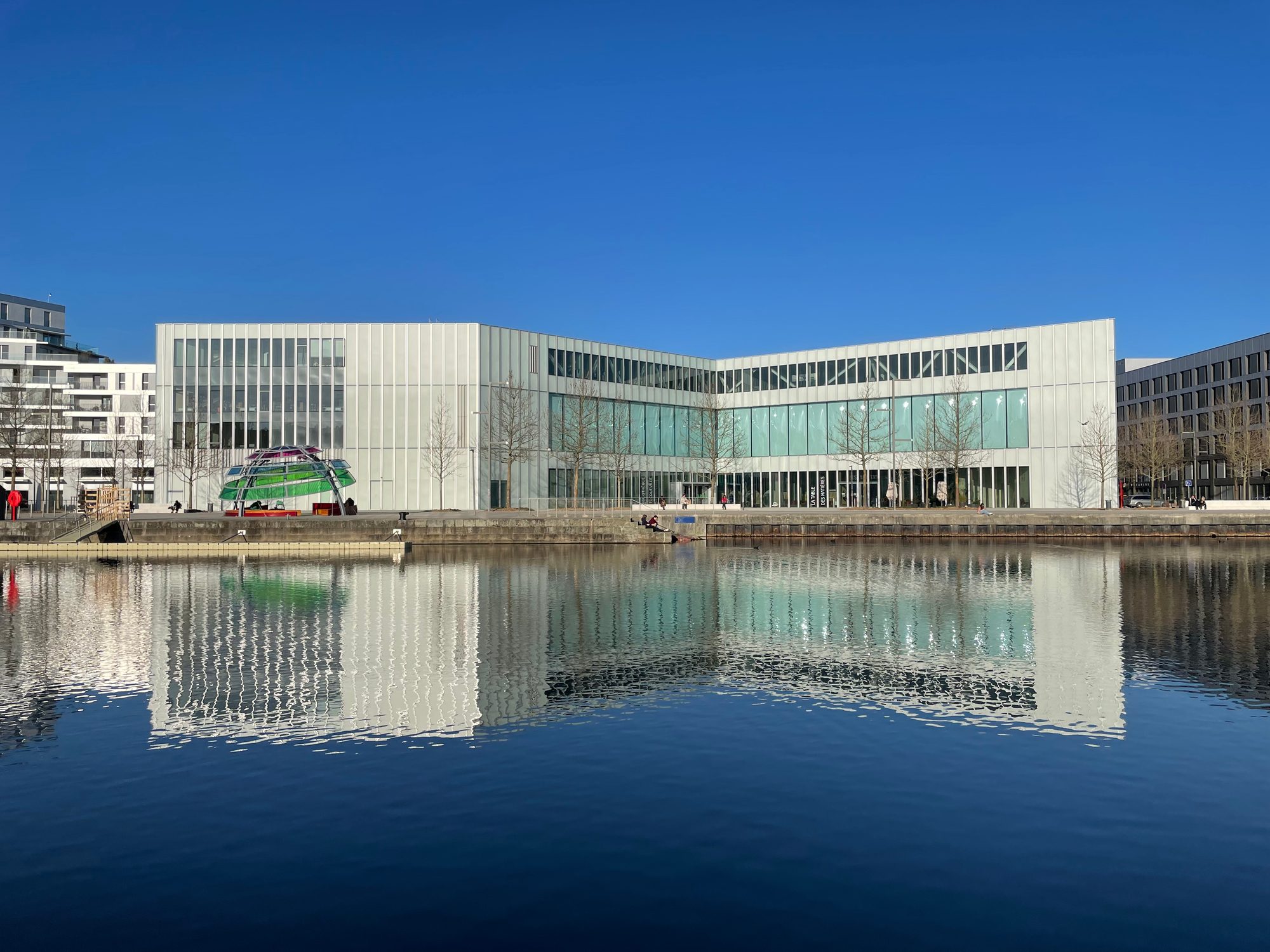 Le bâtiment et la sculpture se reflétant dans le bassin