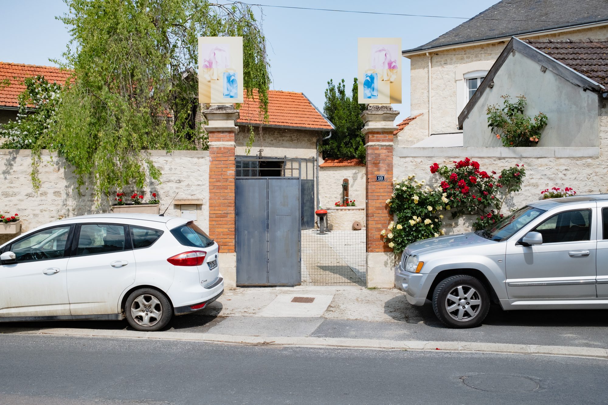 Portail blanc avec photographies sur les piliers