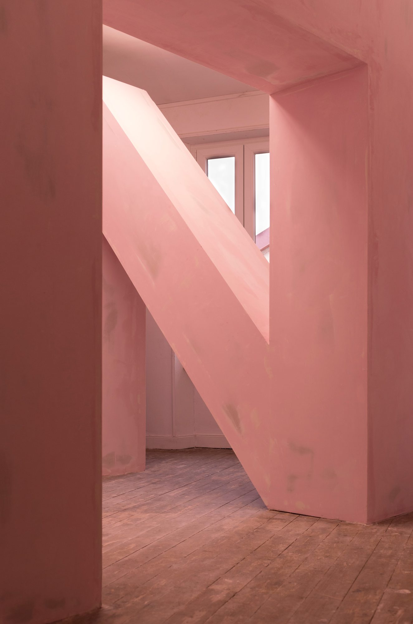 Grande ossature rose en forme de N occupant la pièce
