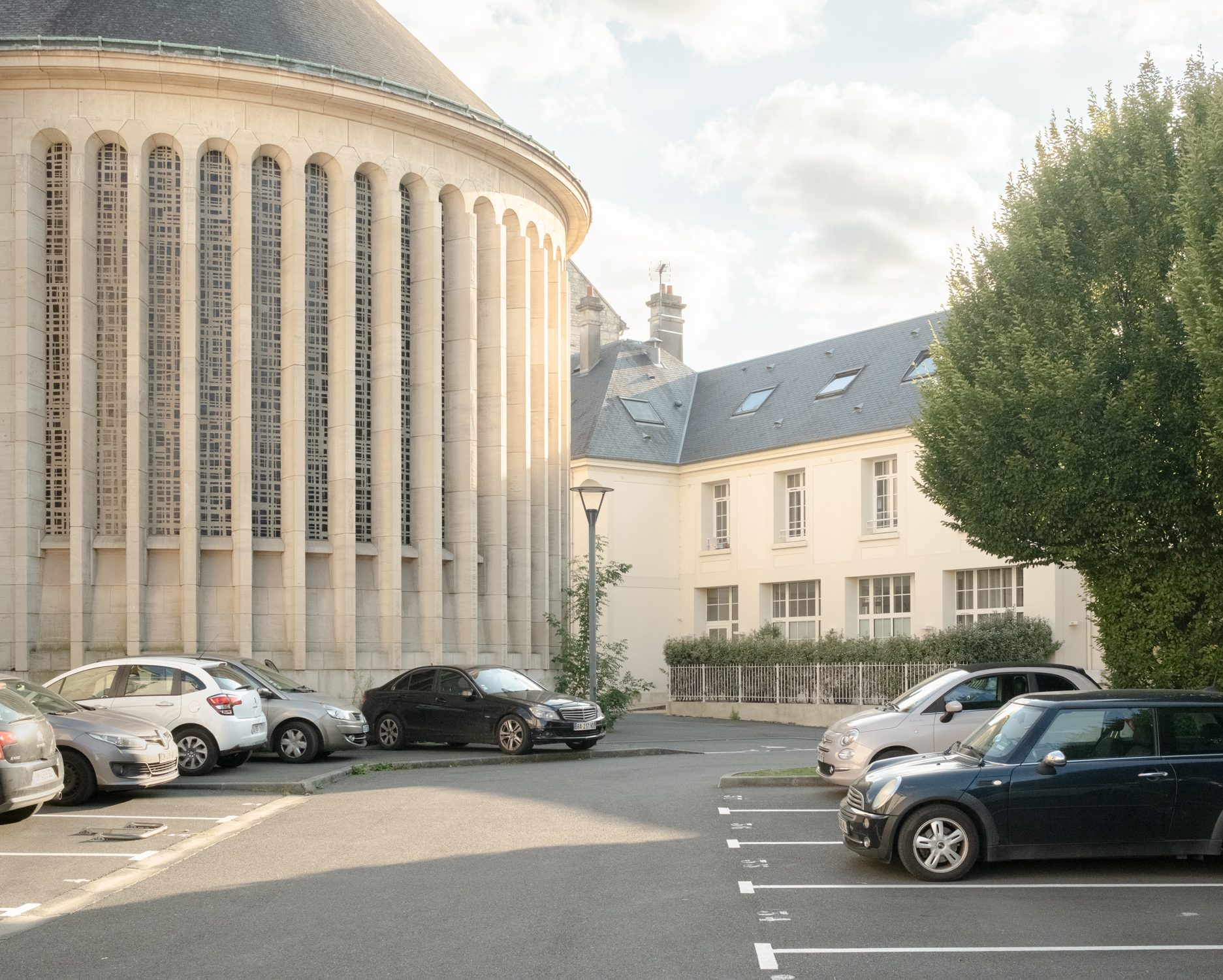 Parking au pied d’un bâtiment arrondi à colonnes