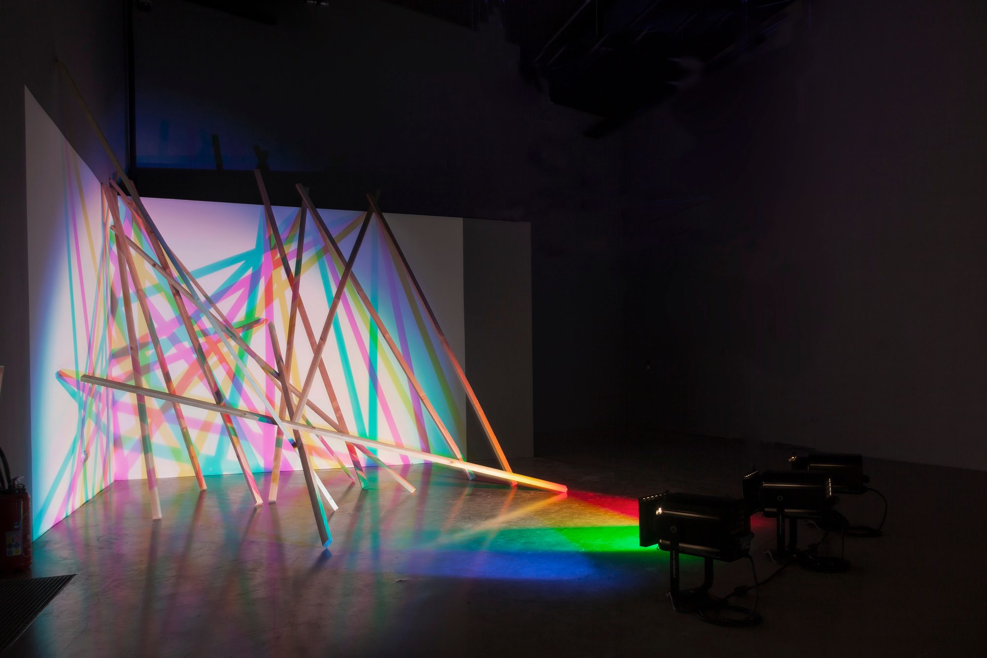 Installation dans une salle sombre, projecteurs au sol