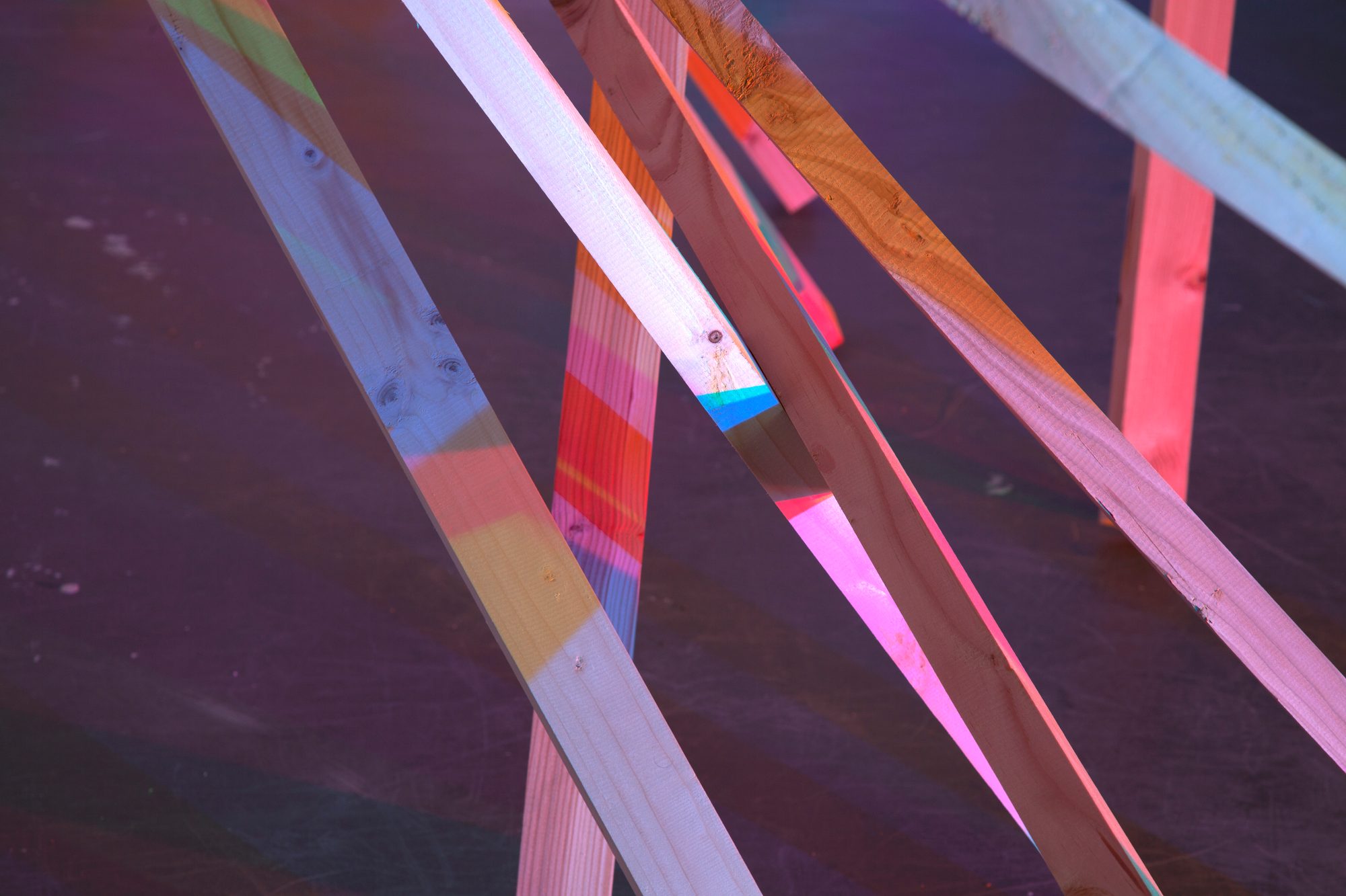 Gros plan sur des tasseaux traversés de lumière colorée